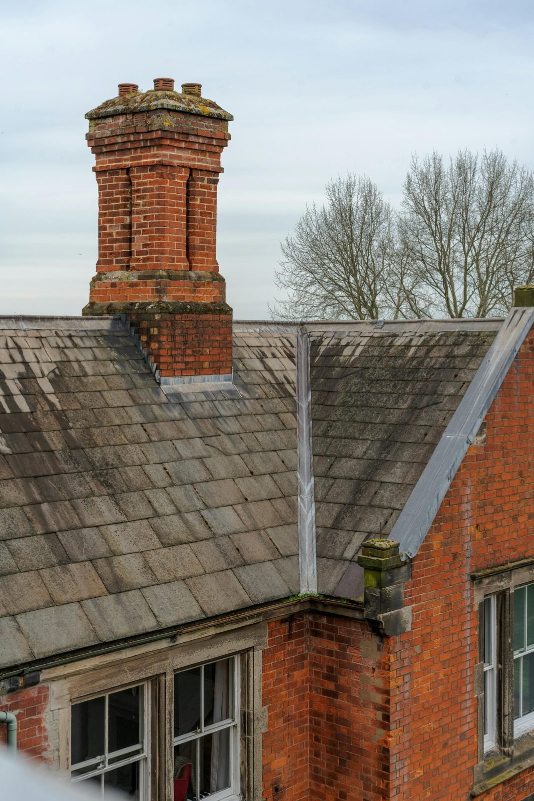 Brick chimney on a slate-roofed heritage building