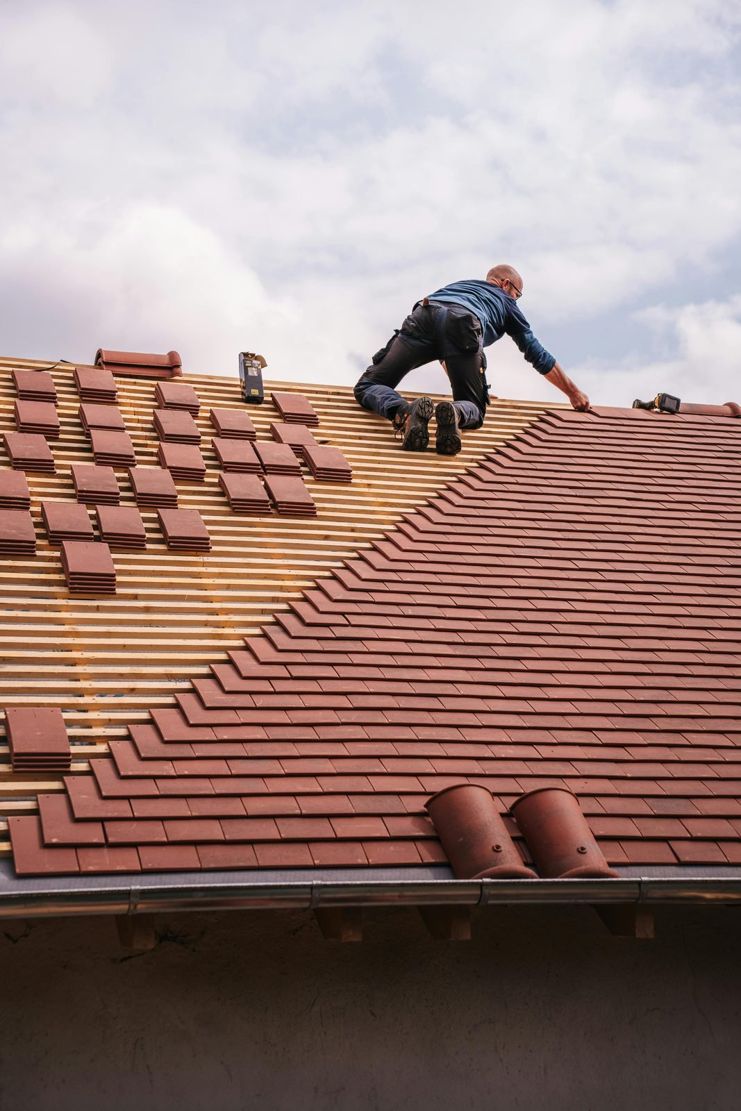 Roofer laying terracotta tiles